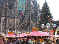 A busy Christmas market set against Cologne Dom and its Christmas tree