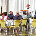 With feet in water, these tourists are enjoying drinks at the Cafe Lavena